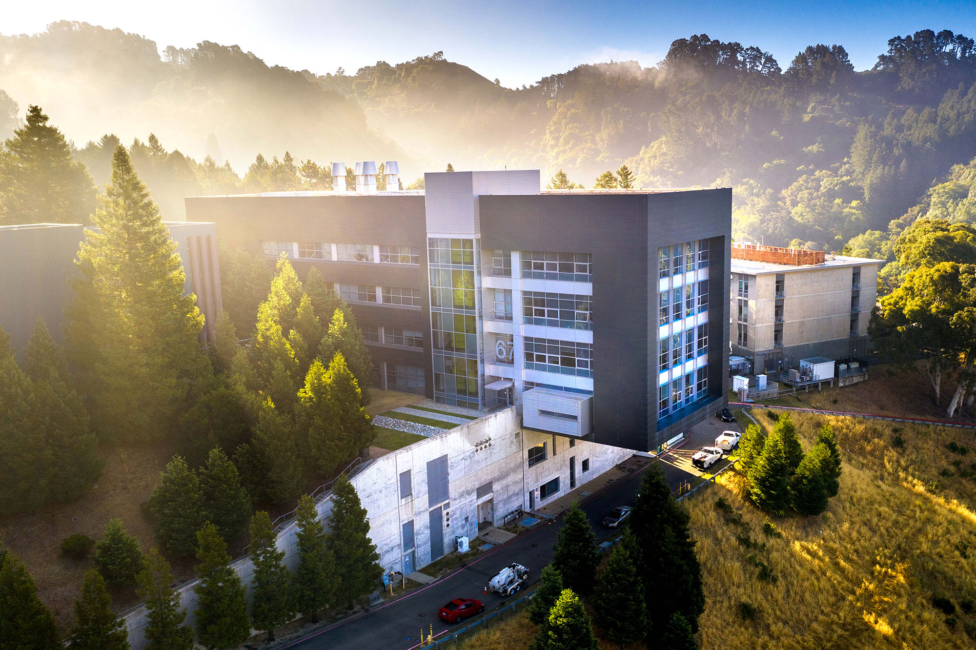 A blue and grey building standing in a foggy forested landscape.