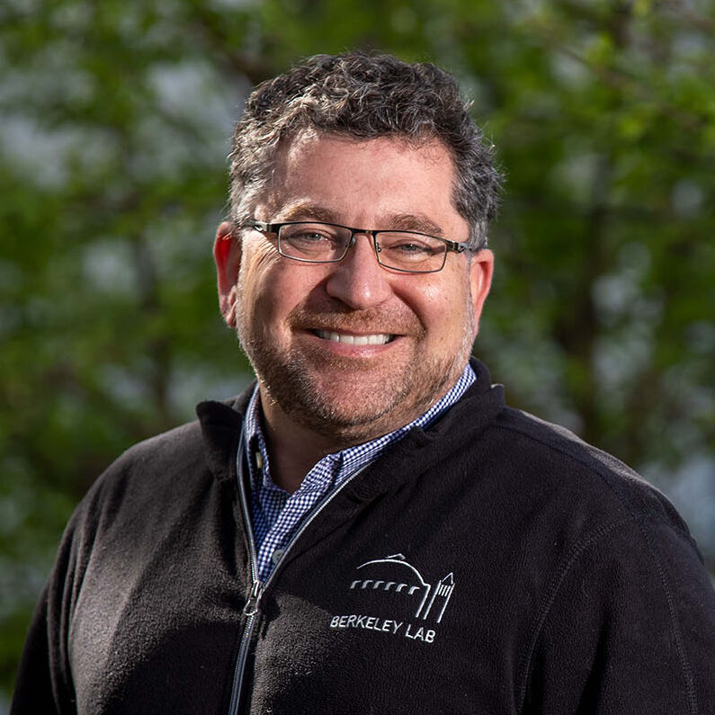 Dark haired person with glasses wearing a black fleece jacket.