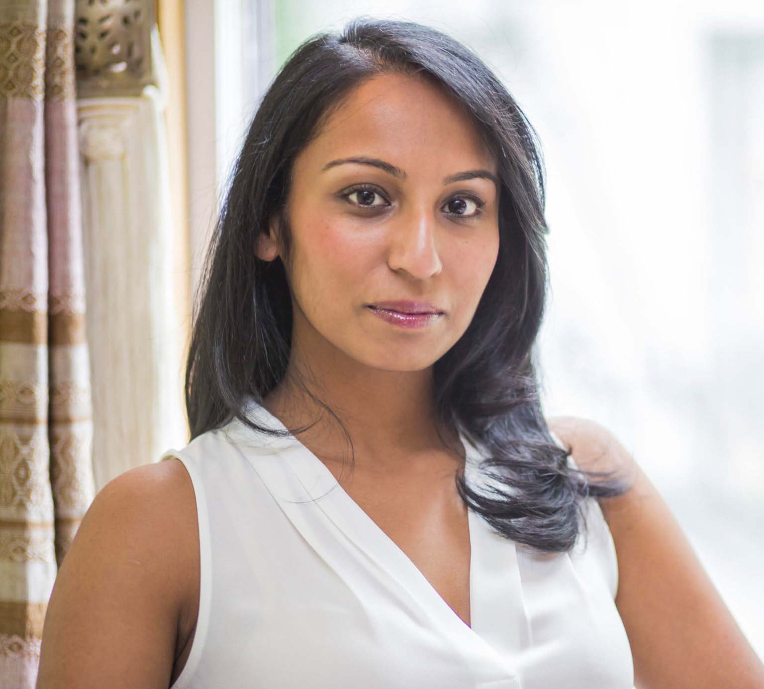 Dark-haired person wearing a white blouse.