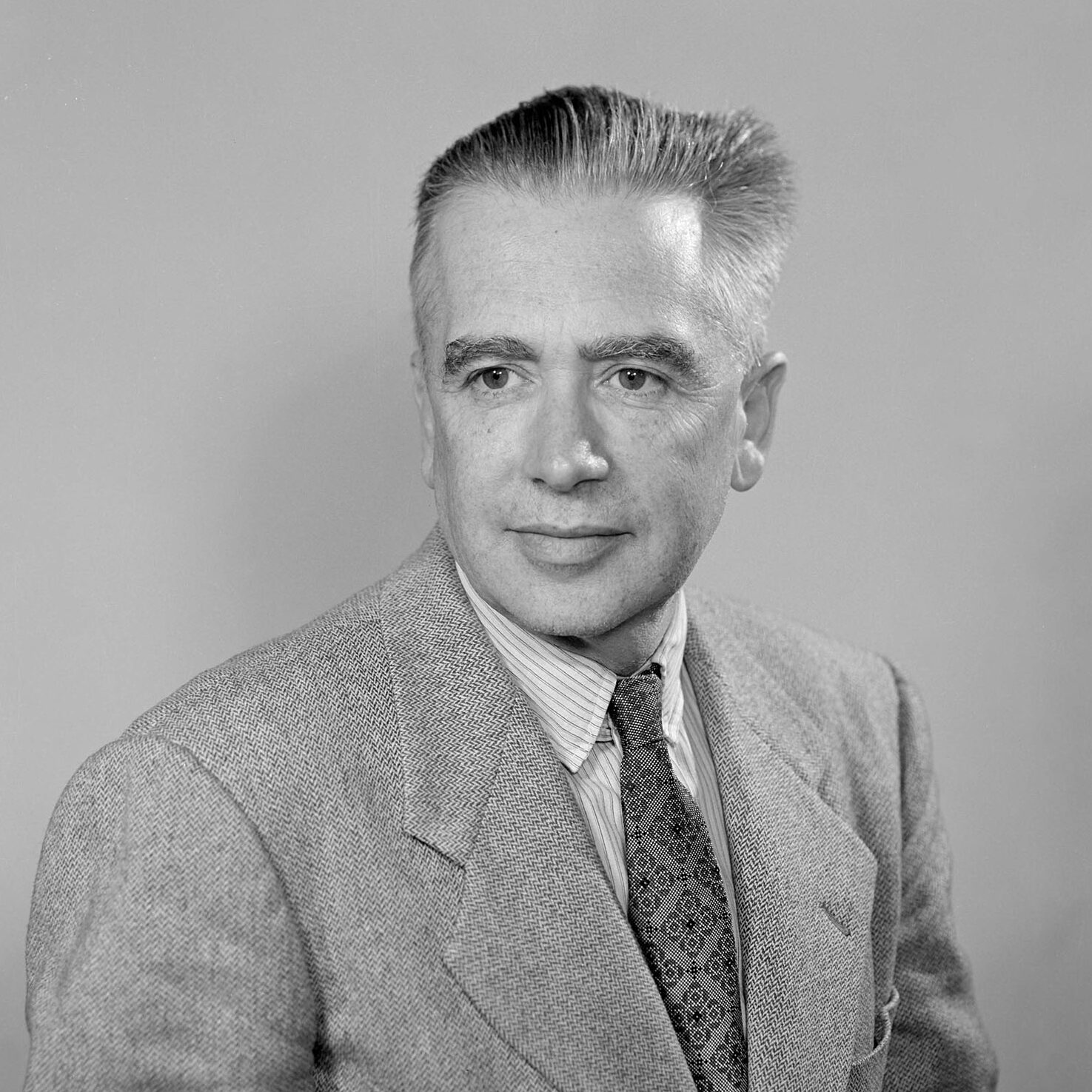 Person with short hair in a suit and tie.