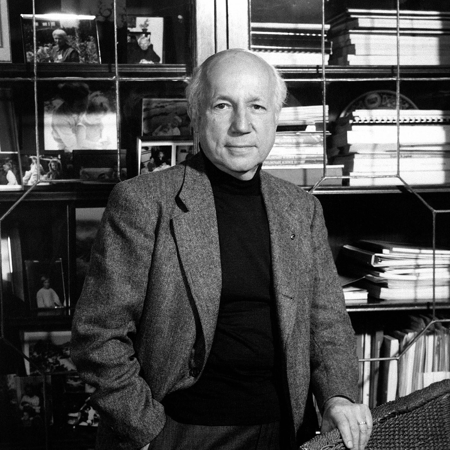 Melvin Calvin, a short-haired person wearing a suit and tie, poses next to a cabinet.