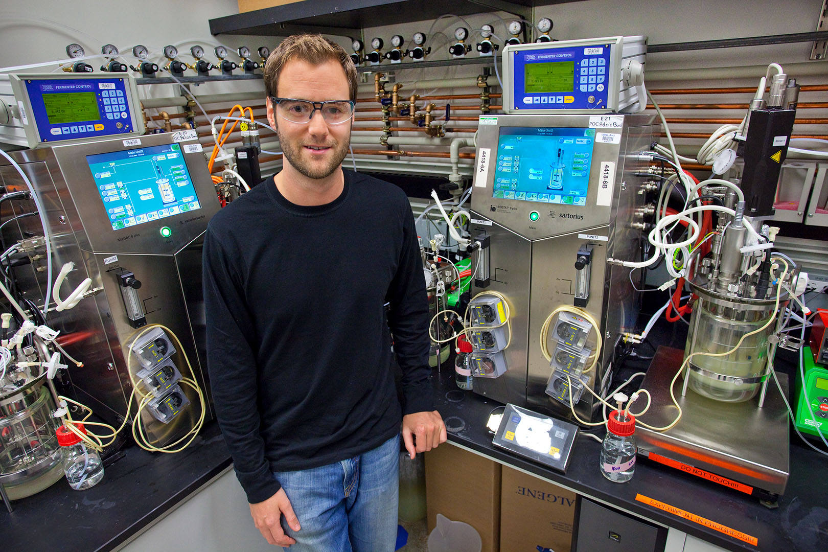 Person in black shirt and jeans standing in front of various machines