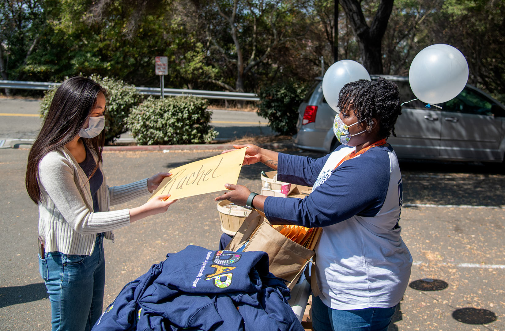 Volunteer hands a packet of educational materials to a student.
