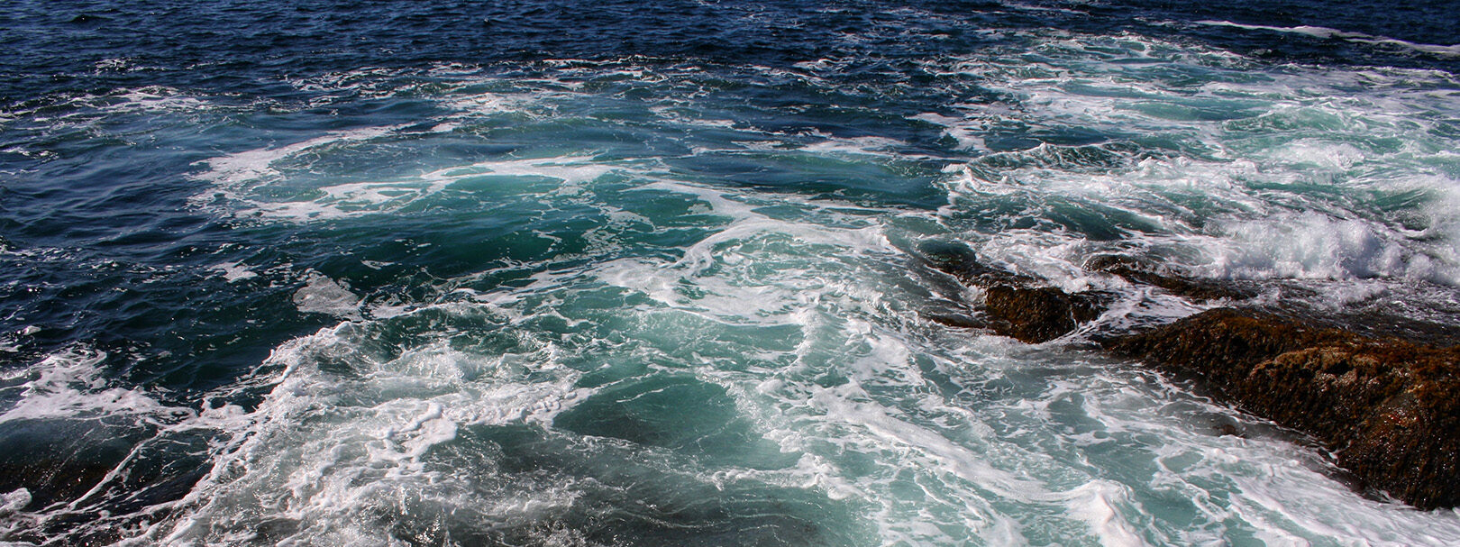 Birdseye view of waves crashing on the shore.