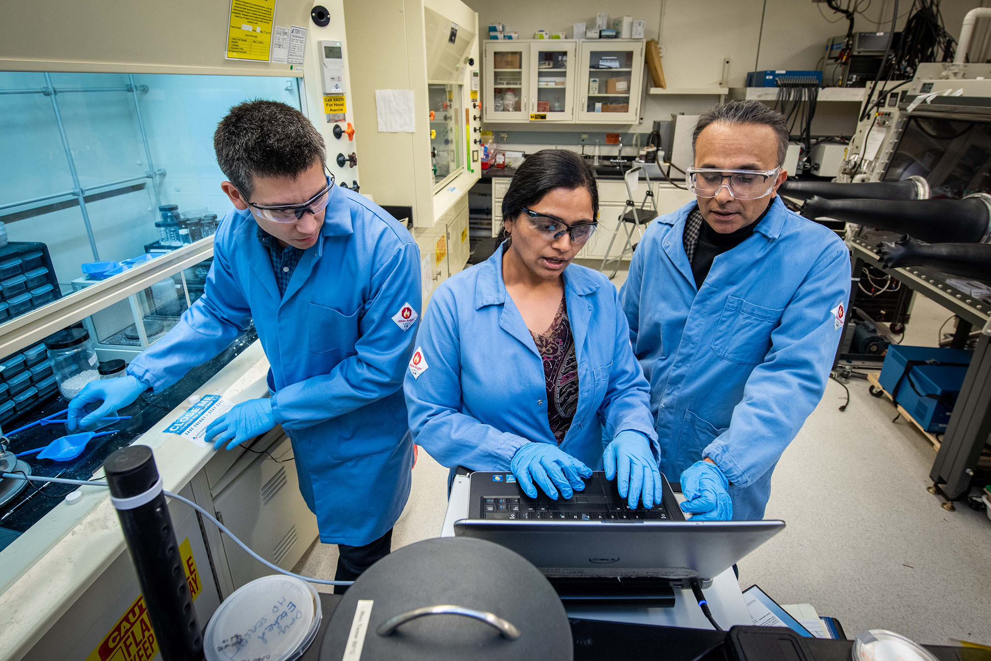Three scientists working together in a laboratory.