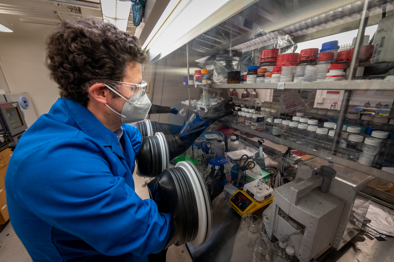 Scientist wearing face covering working in a lab.