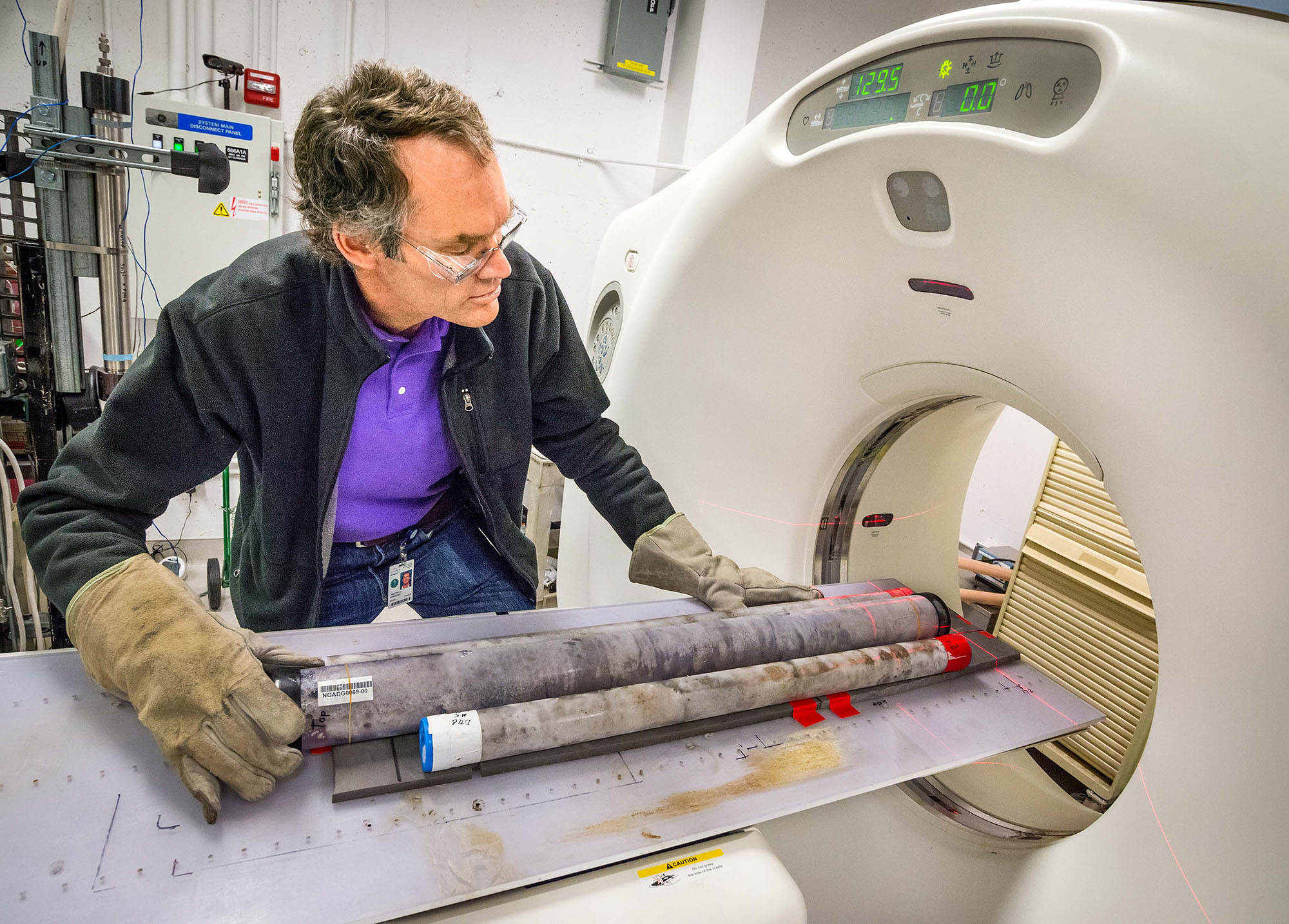 Scientist scanning a soil core in a CT scanner.