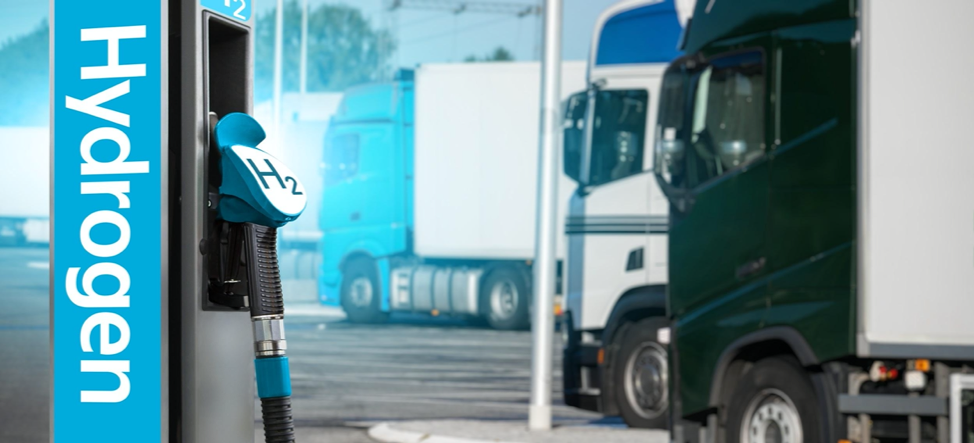 Hydrogen truck refueling station with trucks in the background.