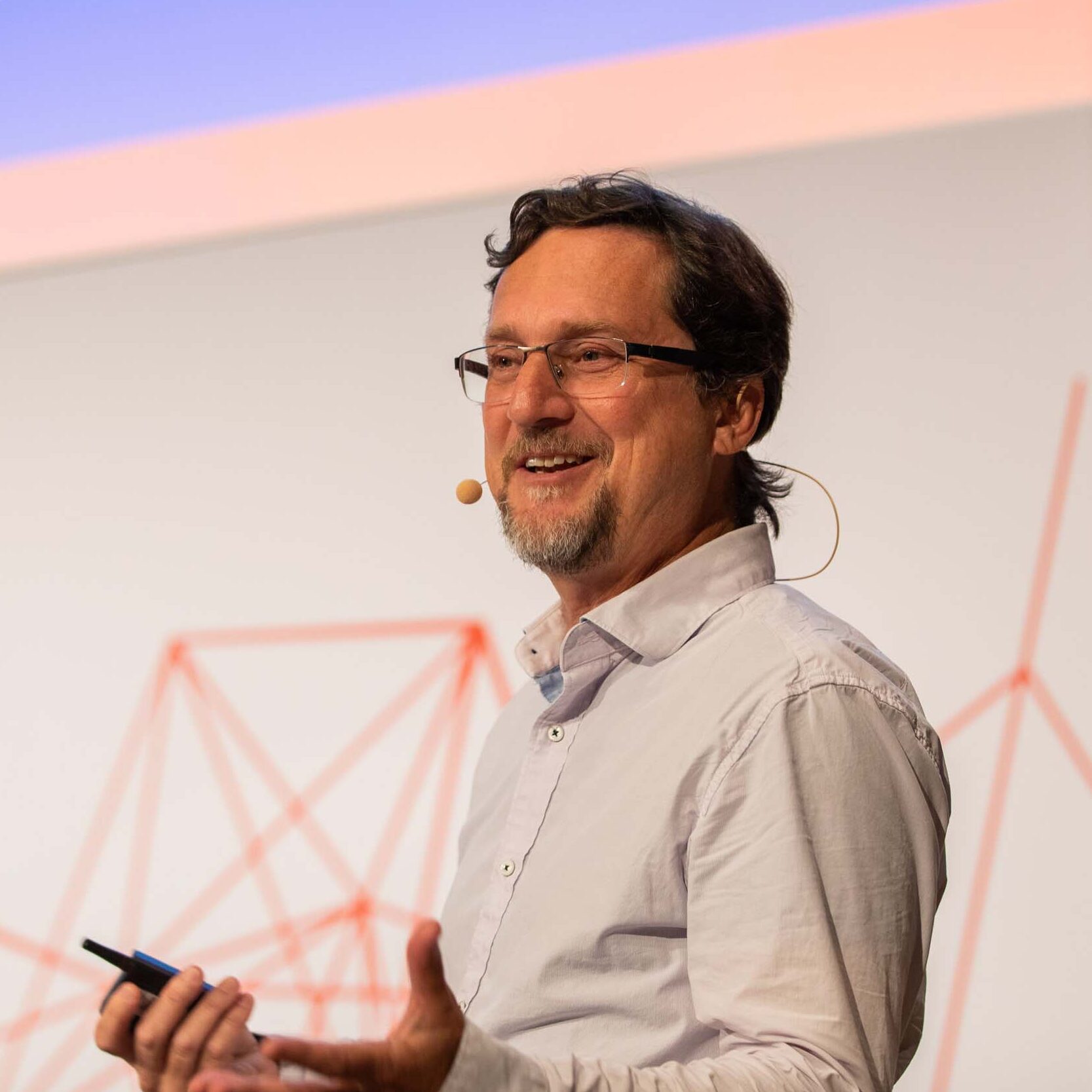 John Shalf, a short-haired person wearing a white collared shirt, speaking at an event.