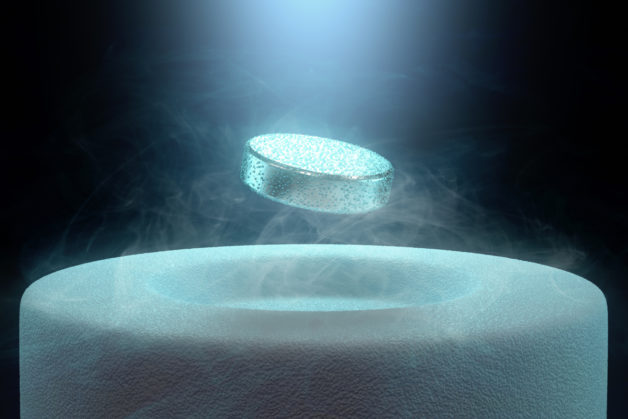 Image concept of magnetic levitating above a high-temperature superconductor, cooled with liquid nitrogen.