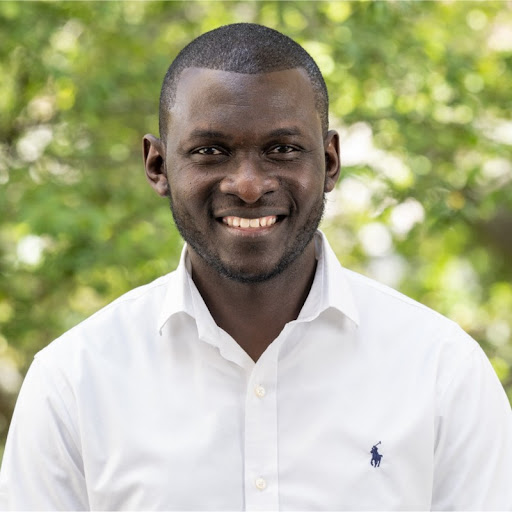 Bashir Mohammed, a dark haired person wearing a white collared shirt, smiles for a headshot.