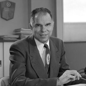 Black and white portrait of Glenn Seaborg sitting at his desk.