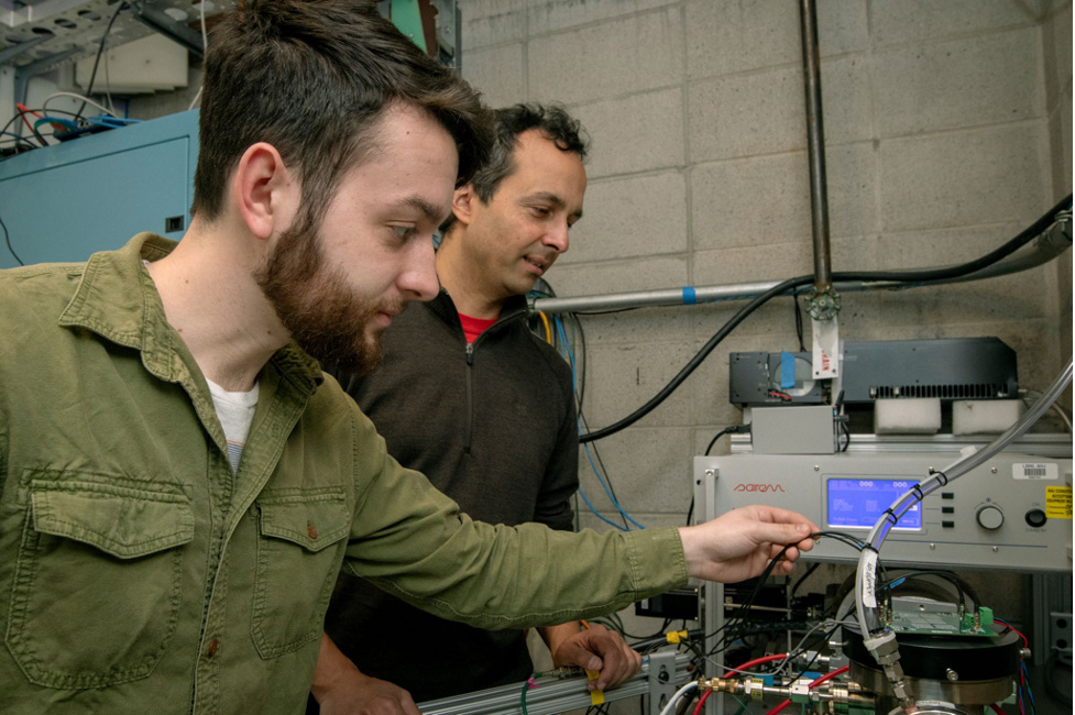 Two people adjusting machinery.