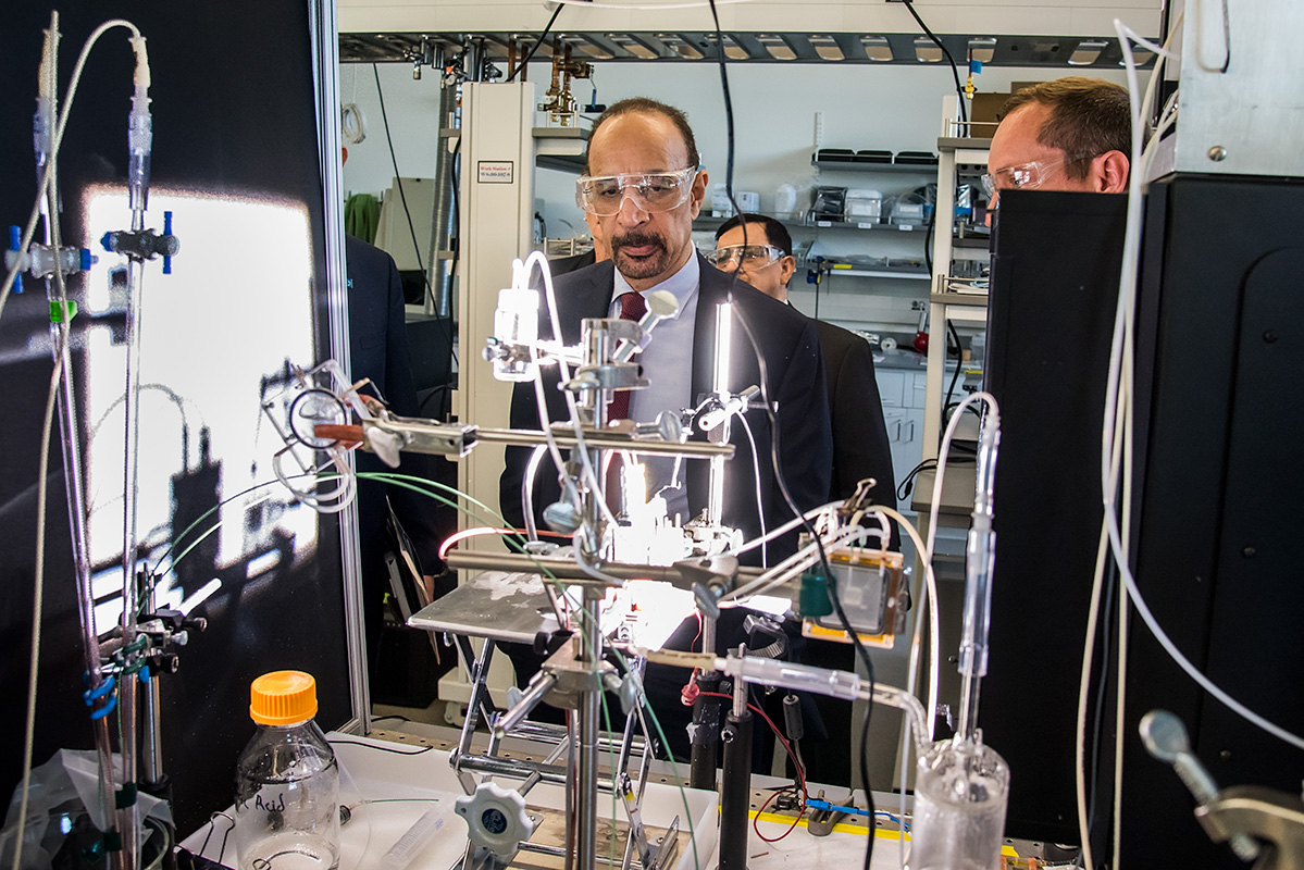 People looking at scientific instrumentation in a lab.