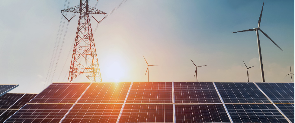Solar panels, electricity tower and wind turbines against the sun.