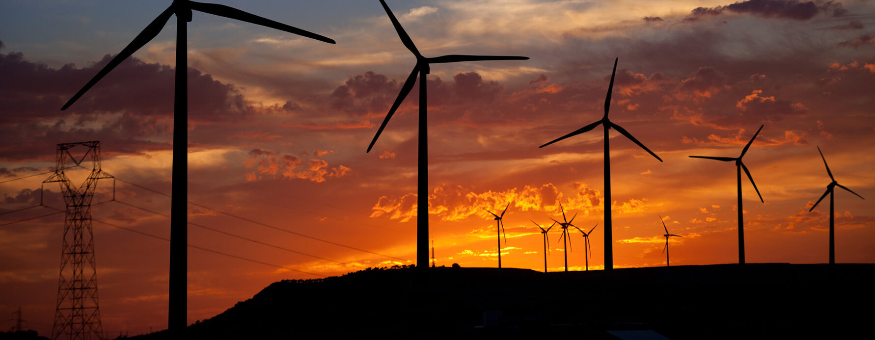 Windmills against a very hot summer sunset.