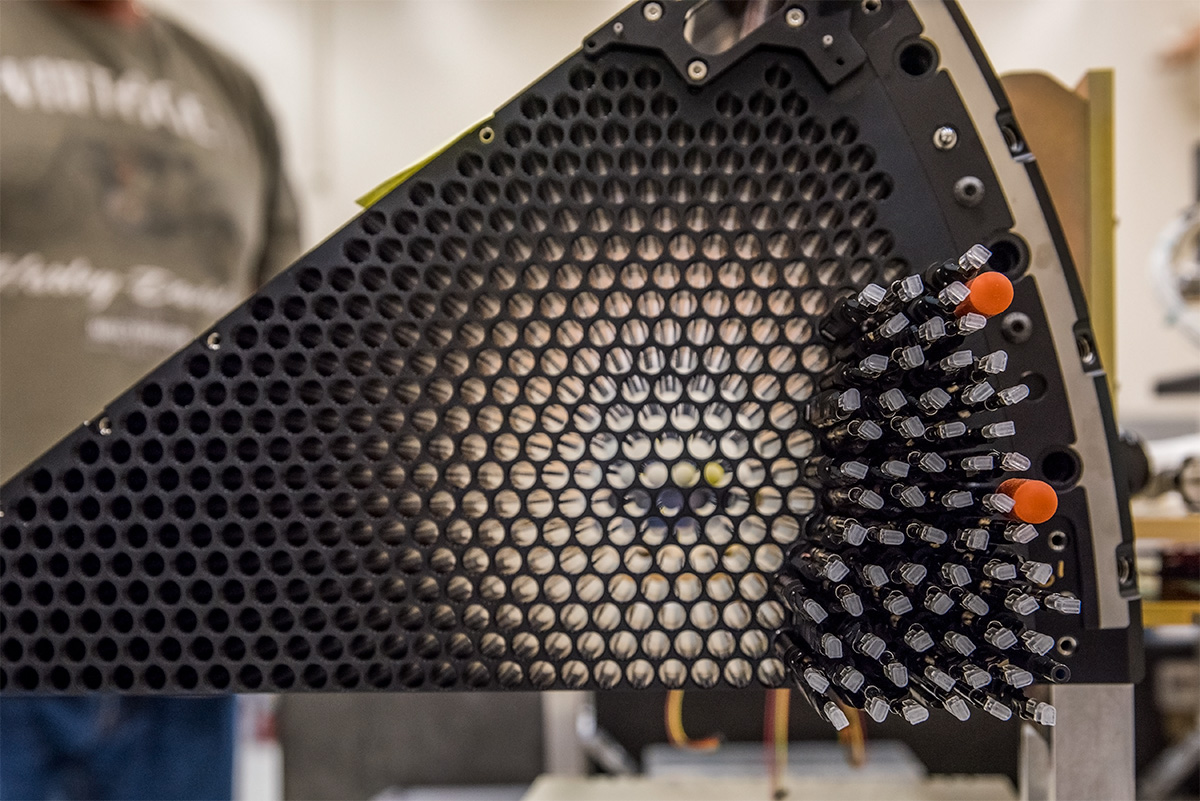 A view of a partially assembled focal plane petal with an array of robotic positioners that is each connected to a fiber.