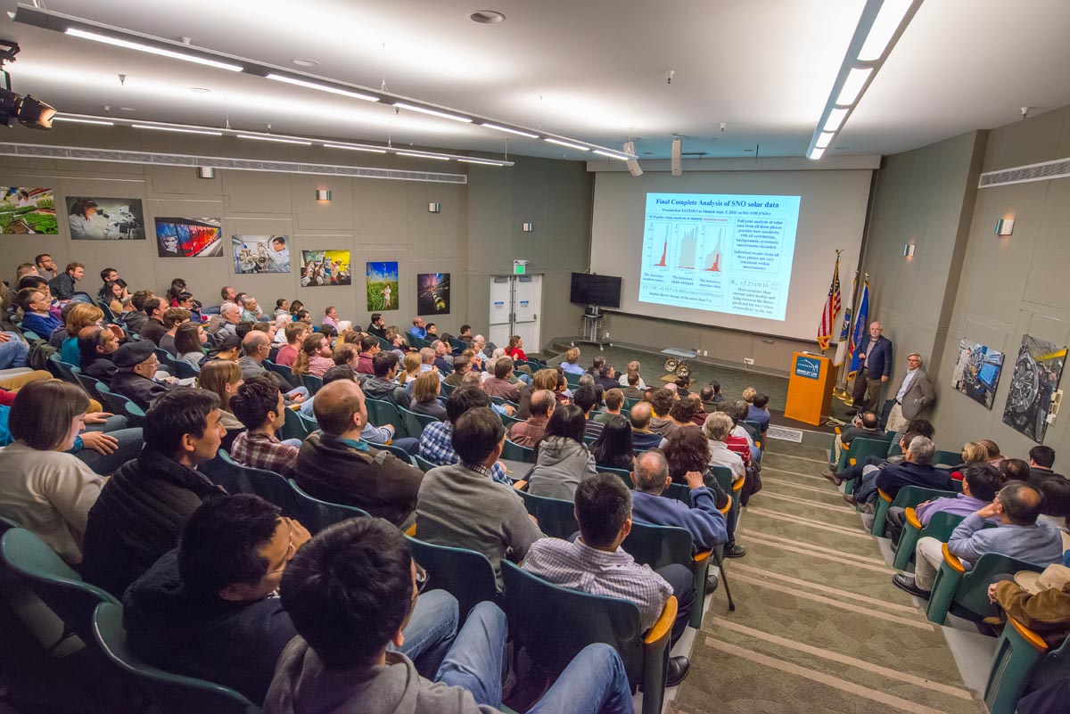 Nobel Prize Physics winner speaks in front of a crowded auditorium.