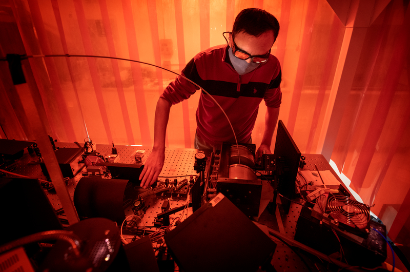 Scientist works in an orange lit laboratory.