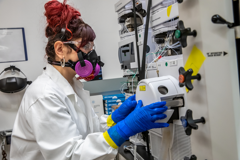 A scientist operating a machine to obtain a small sample of einsteinium.