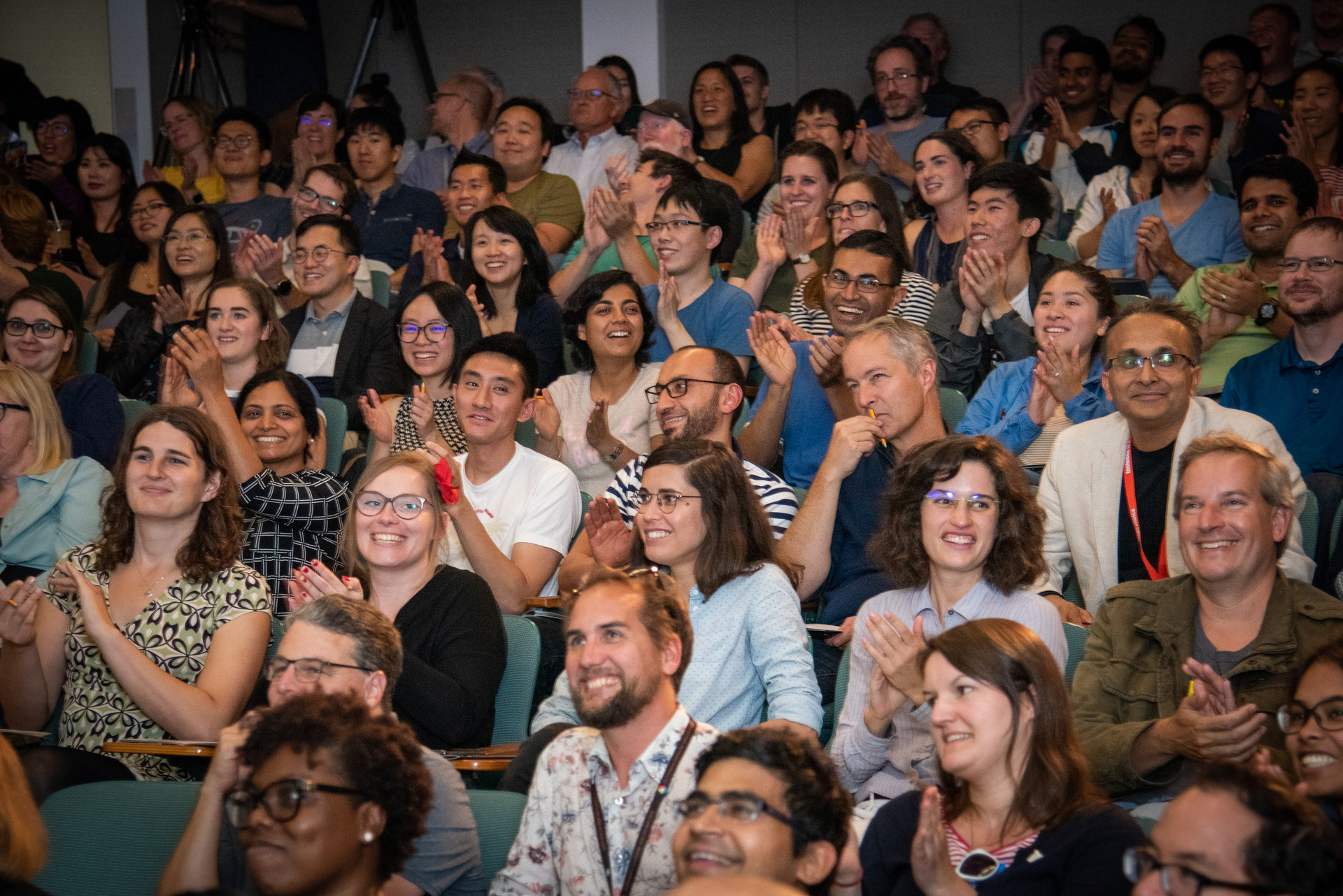 Audience clapping in an auditorium.