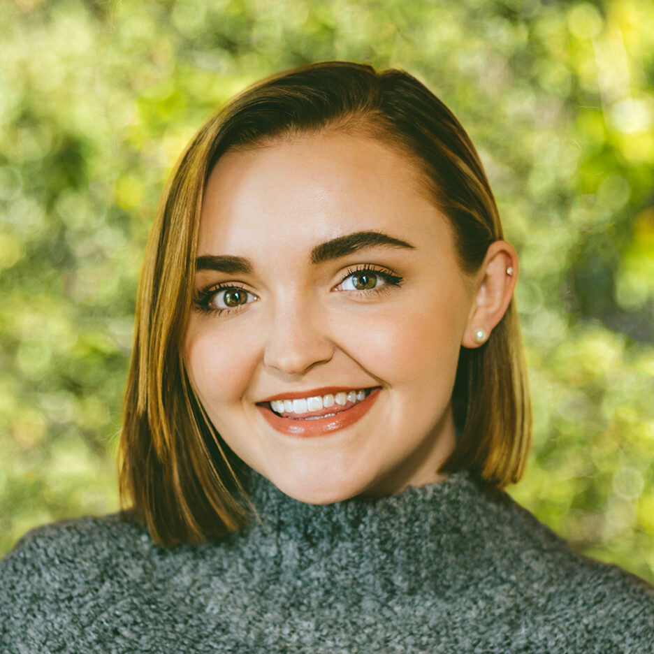 Brown-haired person wearing a gray turtleneck.