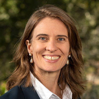 Dark-haired person wearing a white collared shirt under a black blazer.