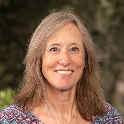 Blonde-haired person wearing a colorful shirt.