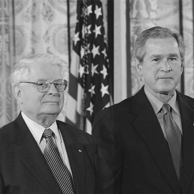 Two men in black suits looking forward.