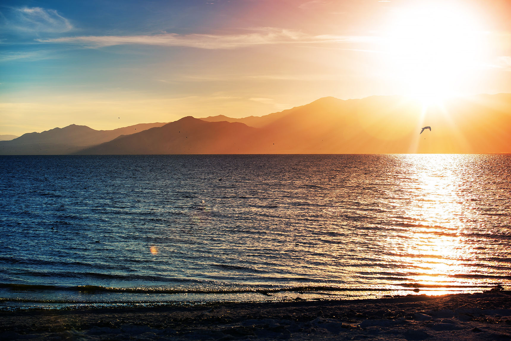 Sunset at the Salton Sea with mountains in the distance.
