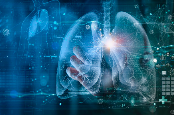 A dark blue, green, and white digital illustration of a set of human lungs on a screen with small coronavirus particles and graphs and medical symbols.