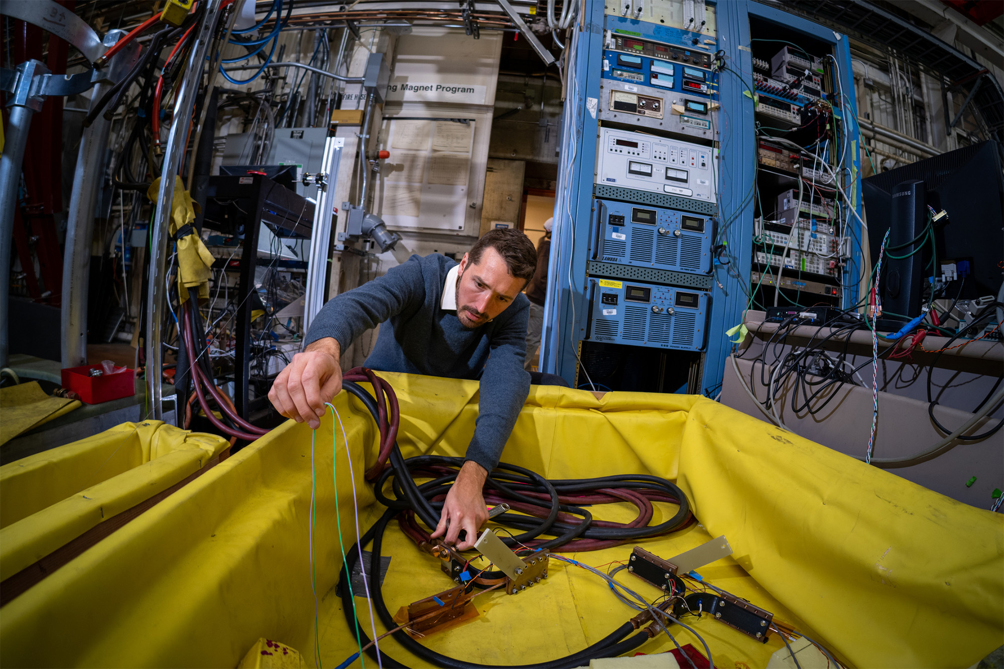 Research scientist Reed Teyber works on a device he developed for measuring high-temperature superconducting magnets.