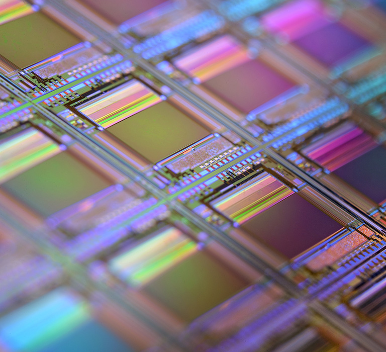 Pink, green, and blue square patterns. Each square is a chip with microscopic transistors and circuits.