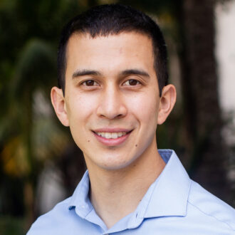 Gregory Su, a person with short dark hair wearing a light blue collared shirt, photographed outdoors.