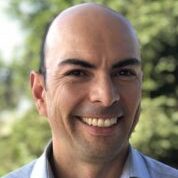 Ricardo Ruiz, a person with wearing a light blue collared shirt, photographed outdoors.