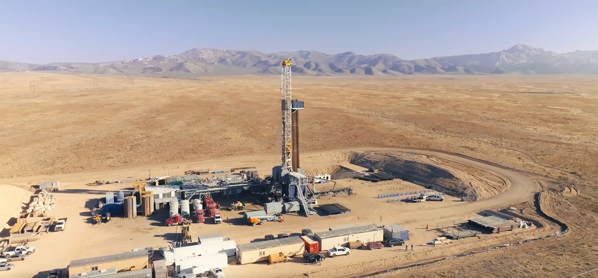 A geothermal plant in front of mountains.