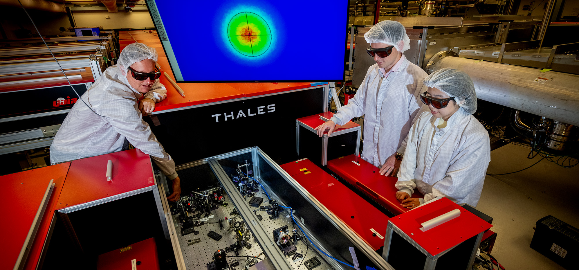Three researchers align precision optics to prepare the Berkeley Lab Laser Accelerator (BELLA) Petawatt laser for laser-plasma accelerator experiments.