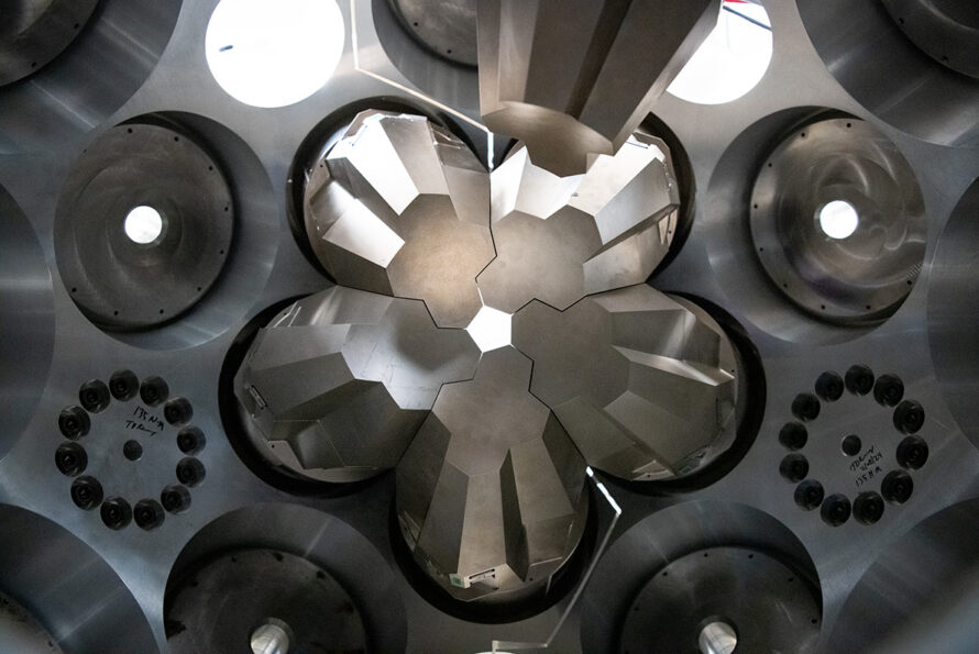 A close-up view of the GRETA interior. Silver-grey modules are arranged in a flower-like configuration around a small central opening. and surrounded by metallic housing with circular ports.