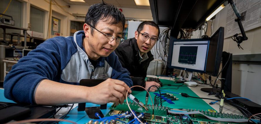 Two researchers working on electronics of research device.