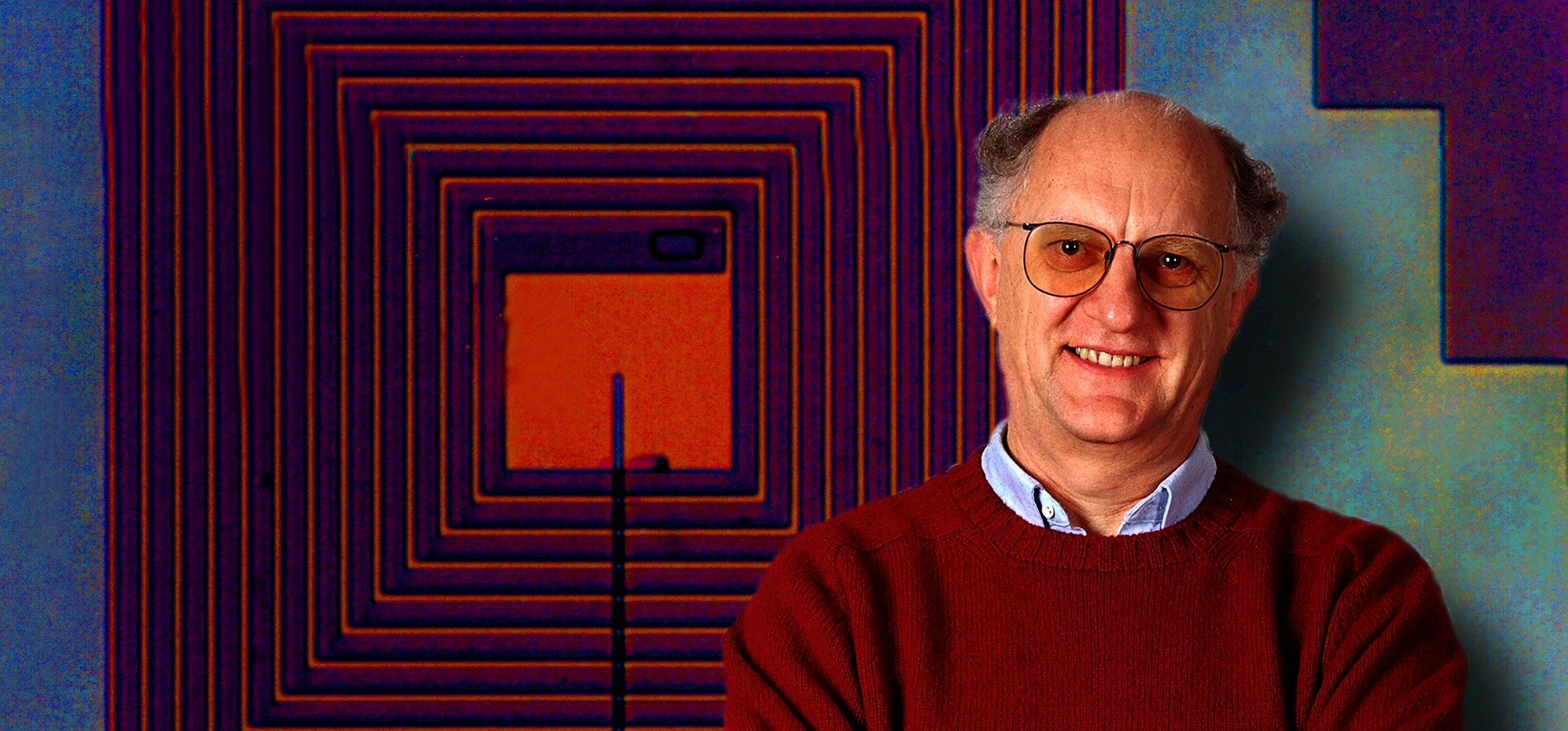 A person in a burgandy sweater is superimposed in front of a red and blue SQUID detector.