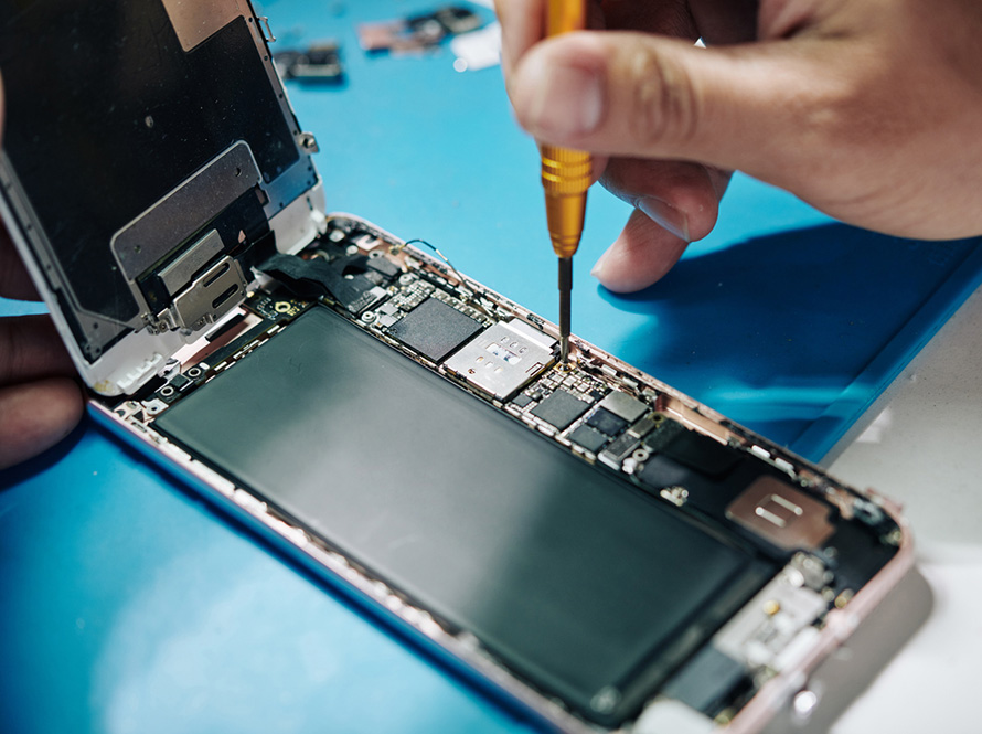 Technician repairing inside of mobile phone by soldering iron.