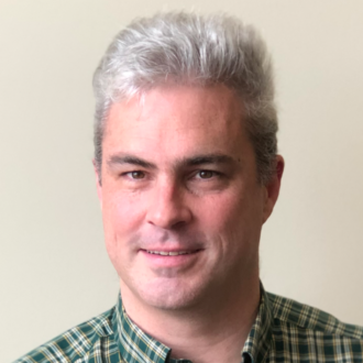 Person with short grey hair and green collared shirt