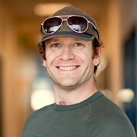 Person with sunglasses on top of cap