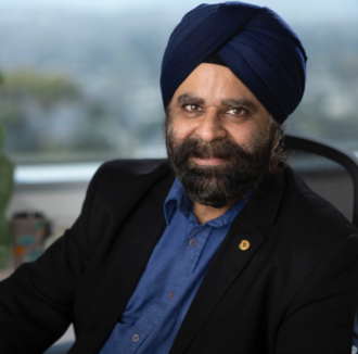 Person with dark hair and a blue turban sitting