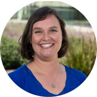 Person in blue shirt and wearing a silver necklace