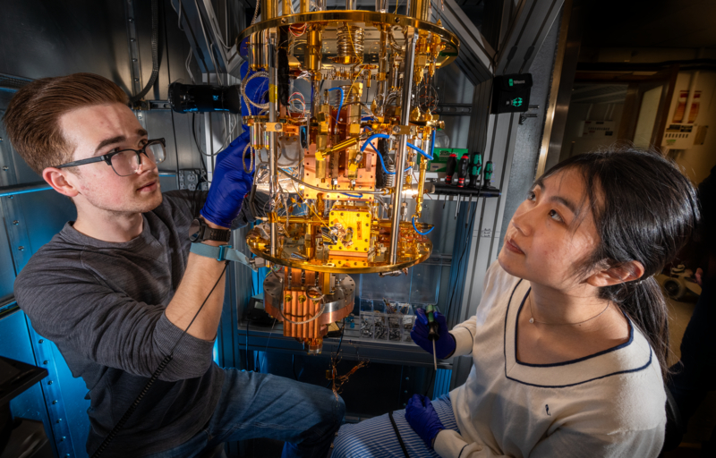 Two people looking at a gold-colored machine