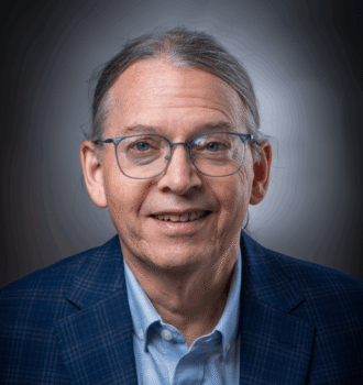 Person wearing glasses and a suit