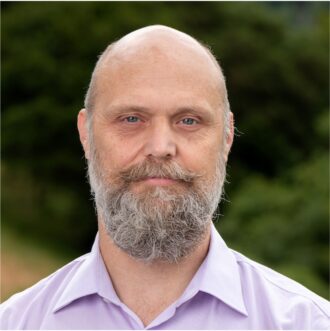 Person with beard and light collared shirt