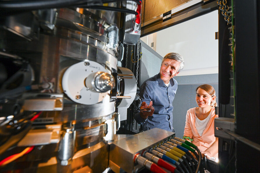 Two researchers looking into a complex microscope setup.